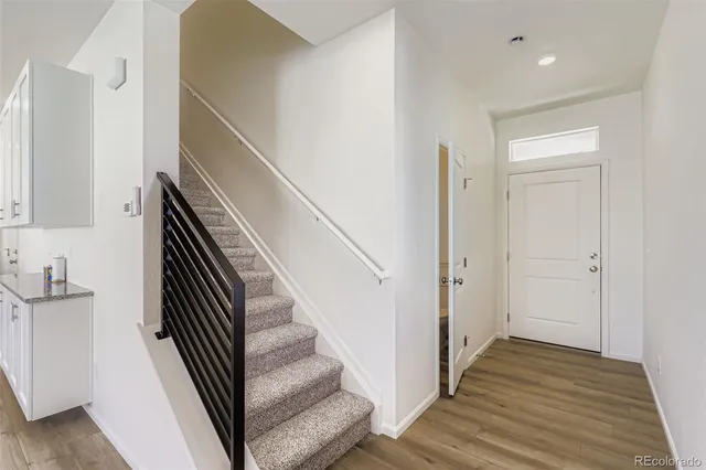 a view of a hallway with wooden floor and entryway