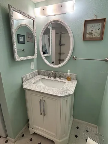 a bathroom with a granite countertop sink a mirror and vanity