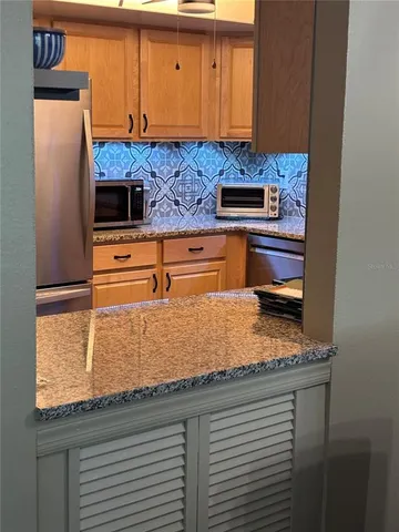 a kitchen with stainless steel appliances granite countertop a sink and cabinets