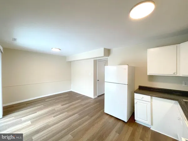 a kitchen with a refrigerator and wooden floor