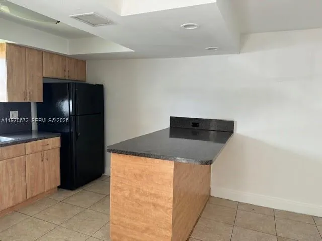 a kitchen with a refrigerator and cabinets