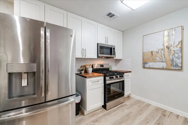a kitchen with stainless steel appliances a refrigerator stove and microwave