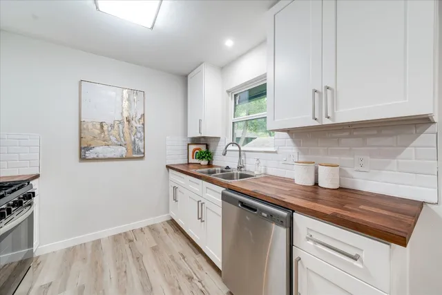 a kitchen with stainless steel appliances granite countertop a sink stove and cabinets