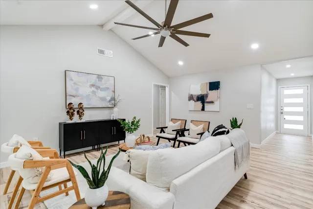a living room with furniture and a wooden floor