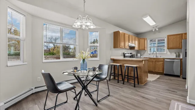 a kitchen with stainless steel appliances a table chairs and chandelier