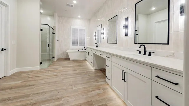a large white bathroom with a double vanity sink a large mirror and shower