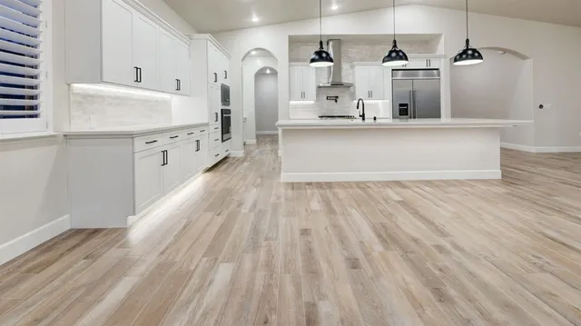 a large white kitchen with cabinets
