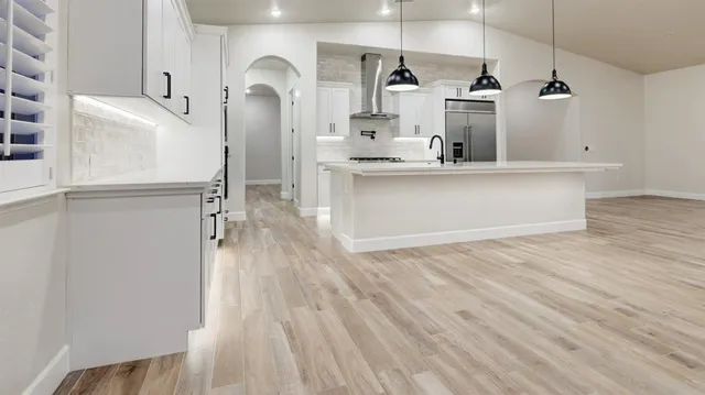a view of a kitchen with wooden floor and electronic appliances