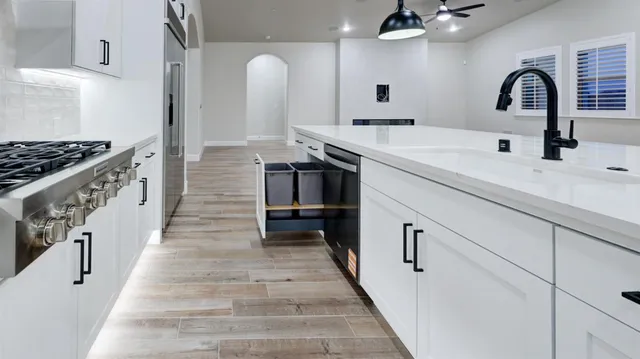 a kitchen with sink a stove and chairs
