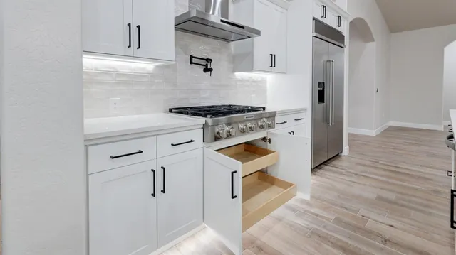 a kitchen with cabinets appliances and wooden floor
