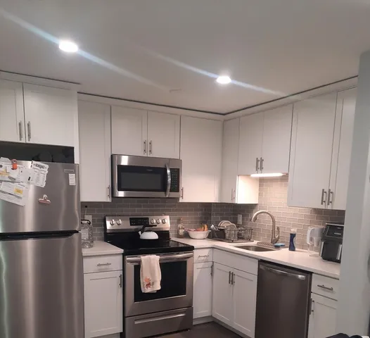 a kitchen with a sink a stove a refrigerator and cabinets