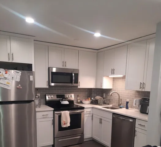 a kitchen with a sink a stove a refrigerator and cabinets