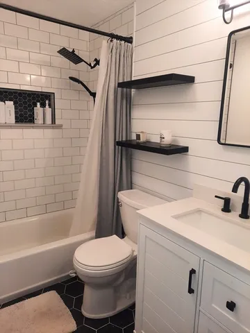 a bathroom with a sink a toilet and shower