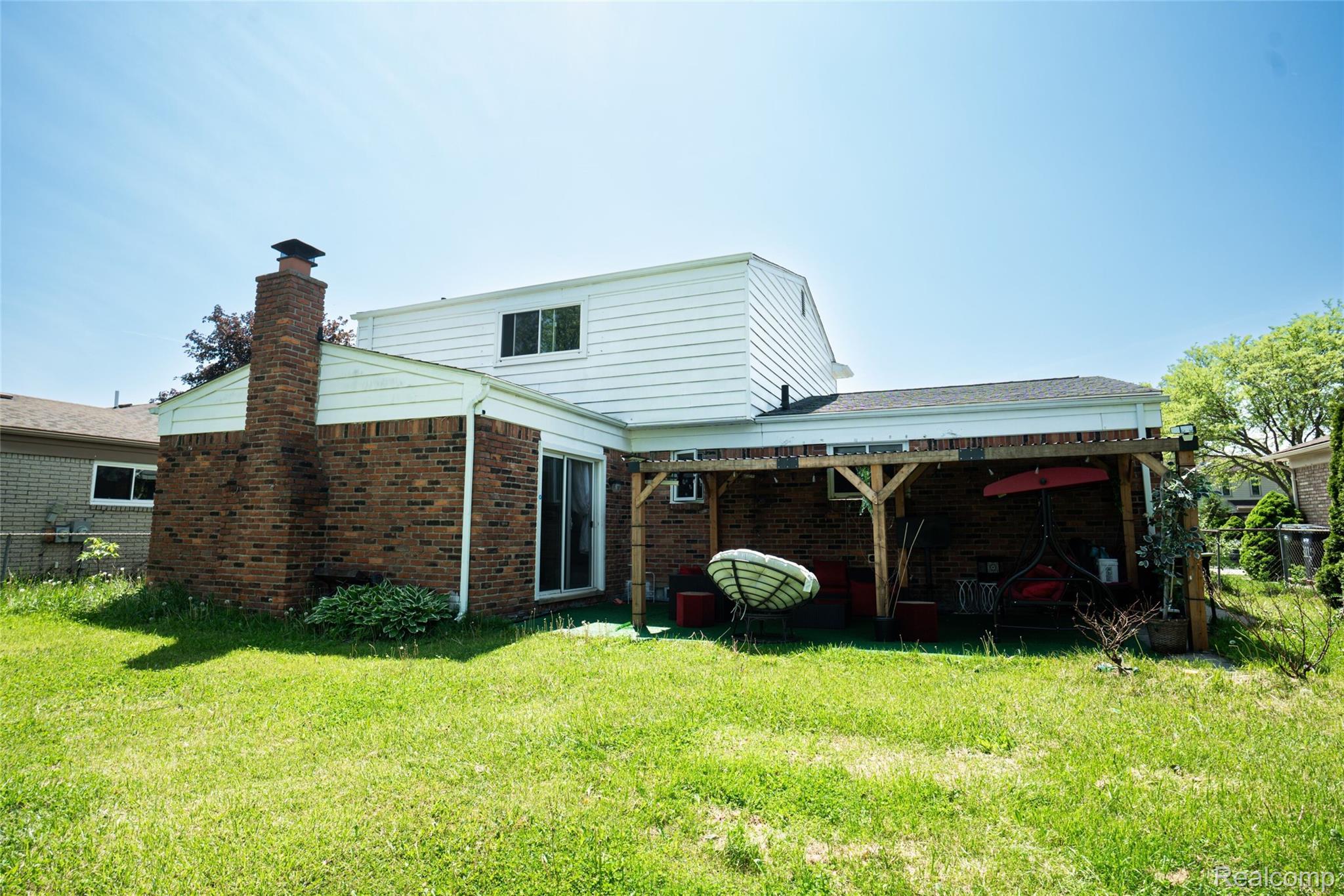 3131 Elmcrest Road Sterling Heights, MI 48310 - Photo 46 of 46 Rear view of house featuring brick siding, a chimney, and a patio