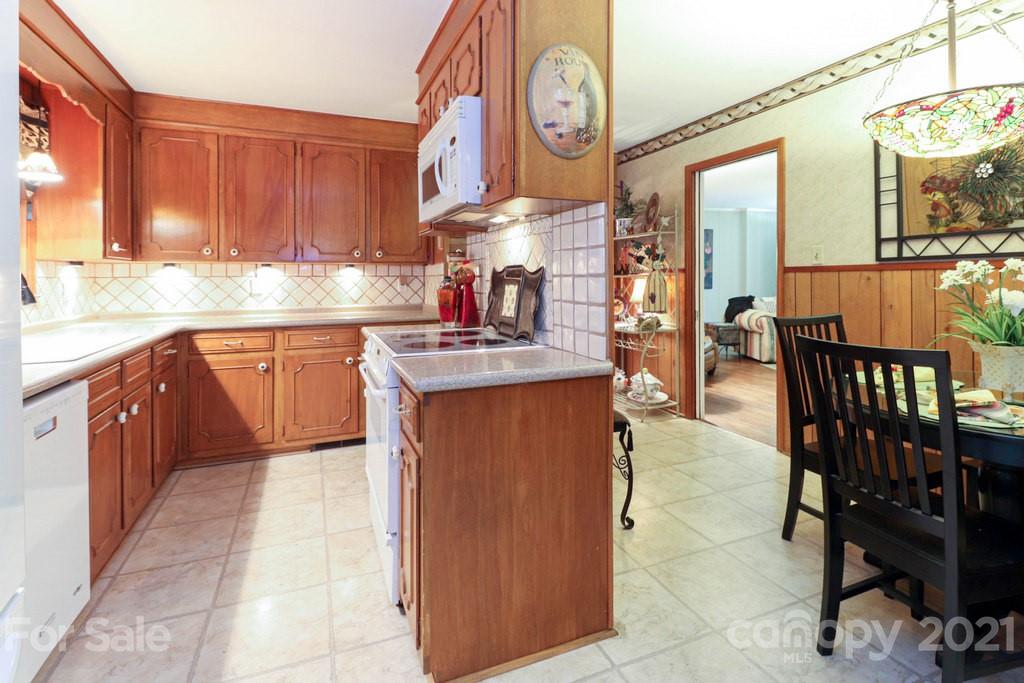 294 Holiday Road Lancaster, SC 29720 - Photo 31 of 48 a kitchen with stainless steel appliances granite countertop a stove top oven a dining table and chairs with wooden floor
