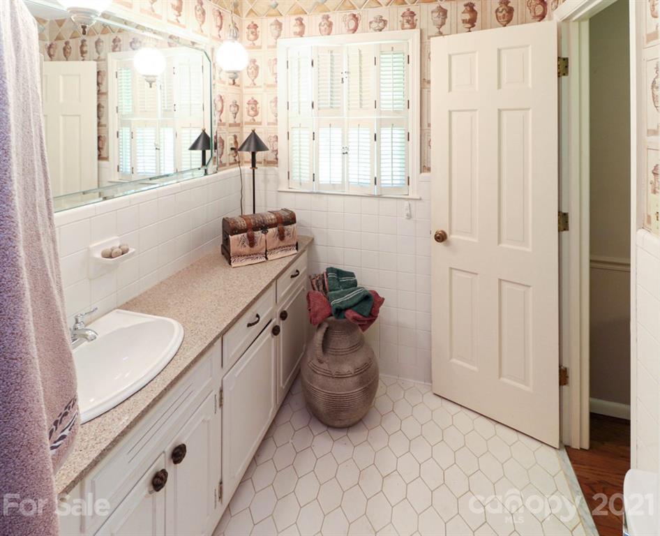 294 Holiday Road Lancaster, SC 29720 - Photo 43 of 48 a bathroom with a granite countertop sink a mirror and a shower