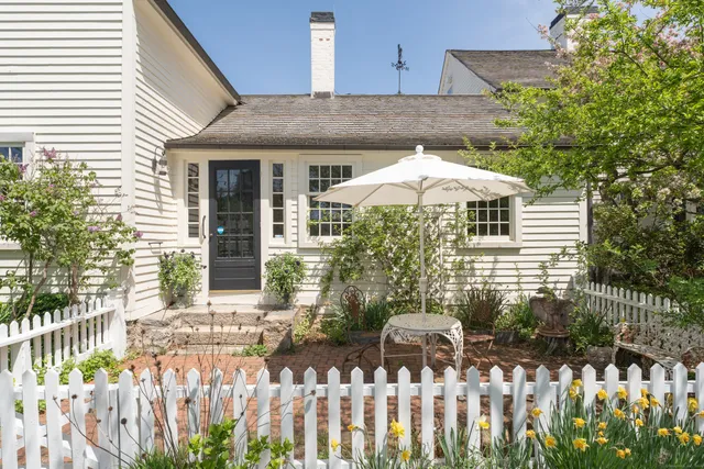 a living room with furniture large windows and wooden floor