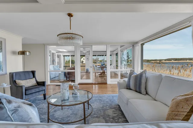 a living room with furniture a fireplace and a chandelier