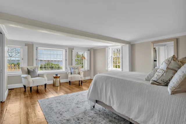 a spacious bedroom with a bed and wooden floor