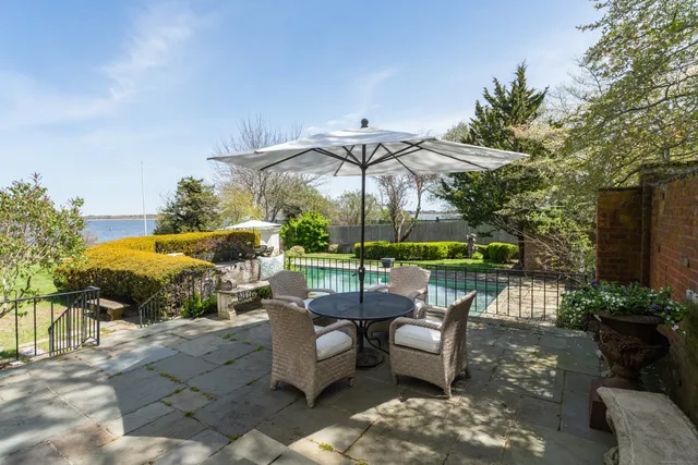 a view of a patio with table and chairs potted plants and large tree