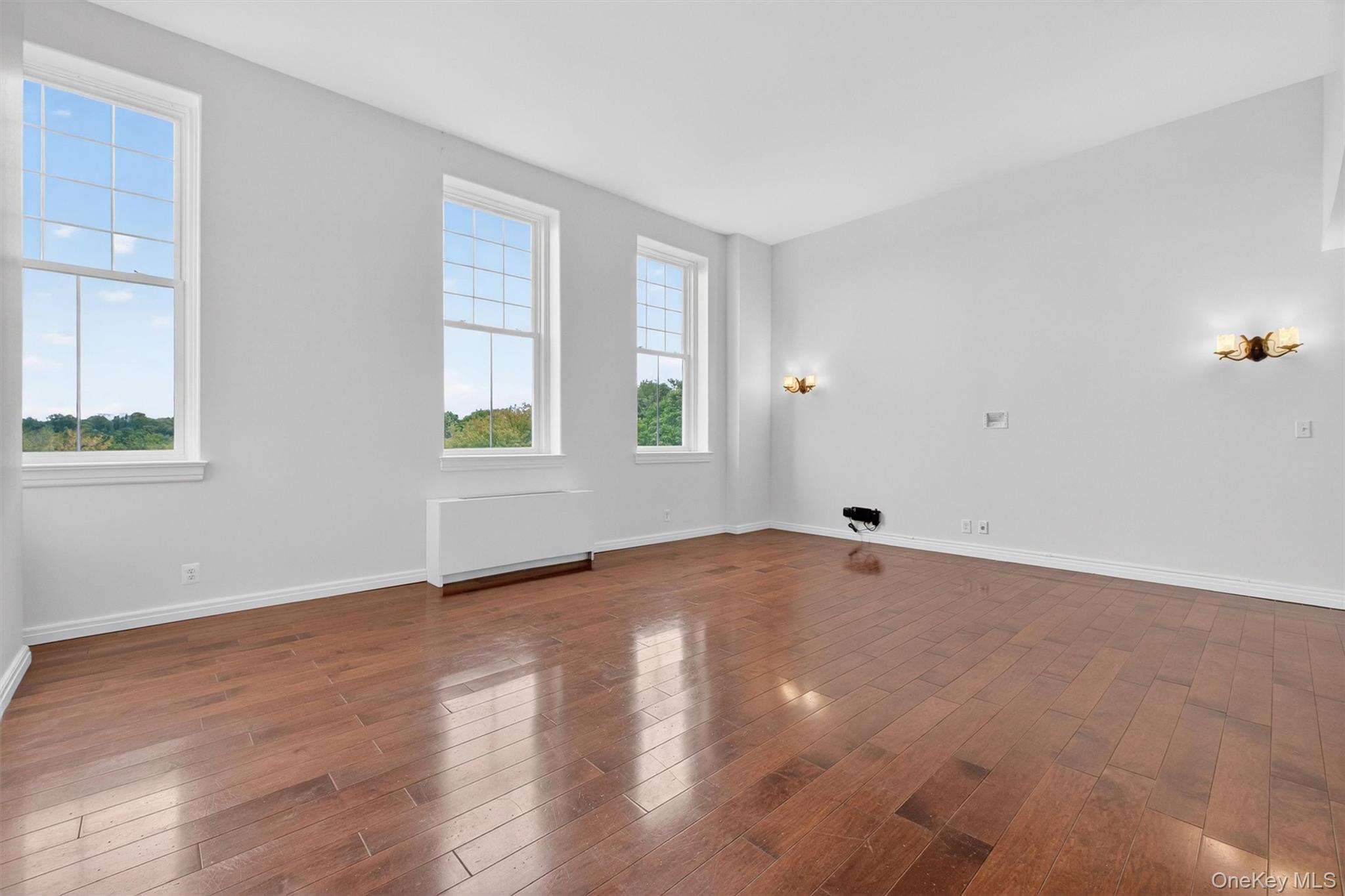 5211 Villa At The Peekskill, NY 10566 - Photo 8 of 19 Another view showcasing the open-concept living and dining area, highlighted by oversized windows, soaring ceilings, beautiful hardwood floors, and an abundance of natural light.