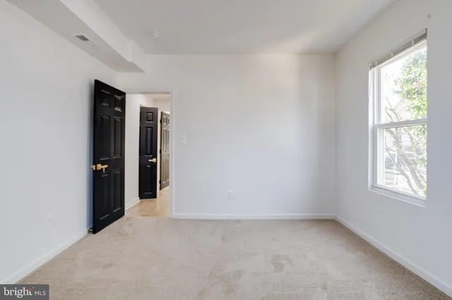 a view of a small space with wooden floor and a window