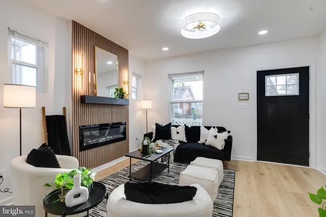 a living room with furniture potted plant a fireplace and a window