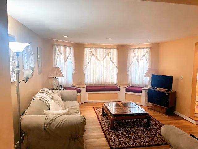 a living room with furniture a large window and a flat screen tv