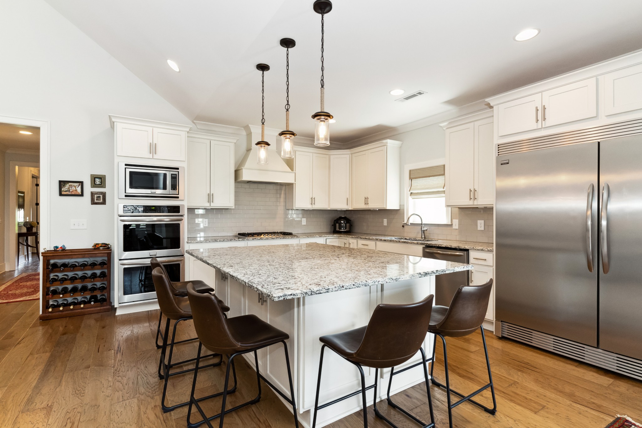 114 Vanner Road Mount Juliet, TN 37122 - Photo 11 of 39 a kitchen with kitchen island a refrigerator a stove a dining table and chairs with wooden floor