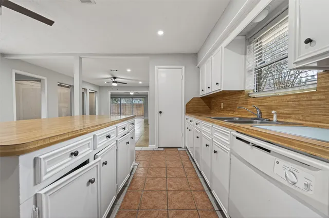 a large white kitchen with granite countertop a sink