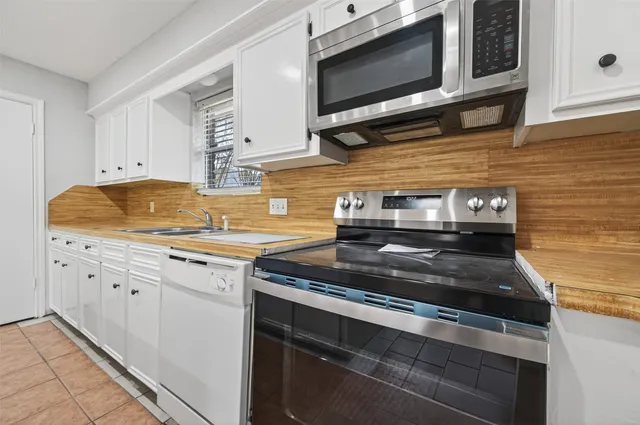 a kitchen with stainless steel appliances granite countertop a stove microwave and cabinets