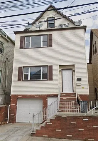 a front view of a house with a parking area