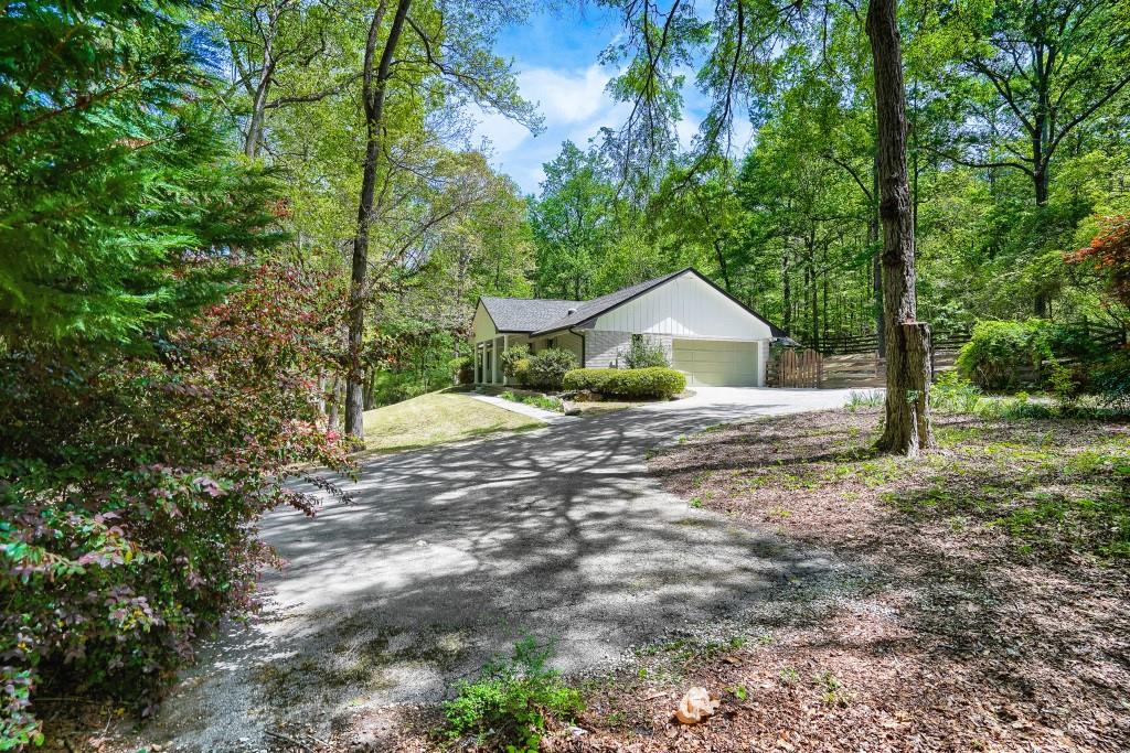 2021 Irwin Bridge Road Northwest Conyers, GA 30012 - Photo 3 of 43 a house is sitting in middle of the forest