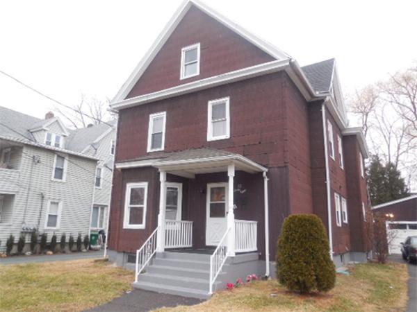 38 Whitman Street Chicopee, MA 01013 - Photo 11 of 15 a view of a brick house with many windows and a yard