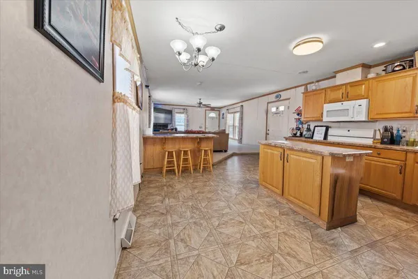 a living room with stainless steel appliances kitchen island granite countertop furniture and a view of kitchen