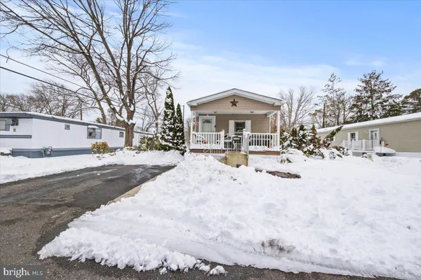 a view of a white house with a yard covered in snow