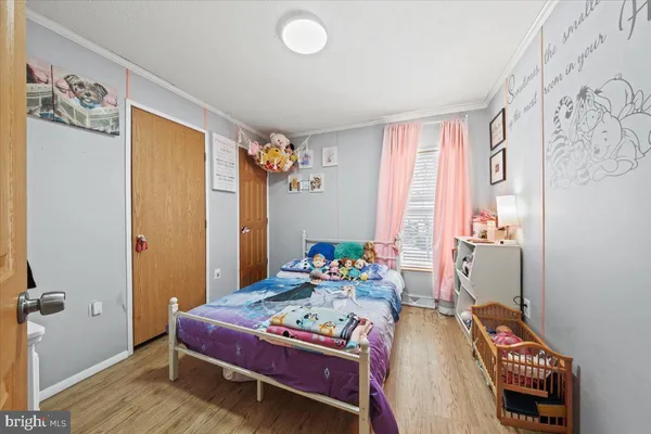 a bedroom with a bed and wooden floor