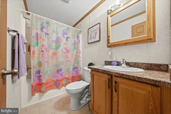 a bathroom with a granite countertop sink and a toilet