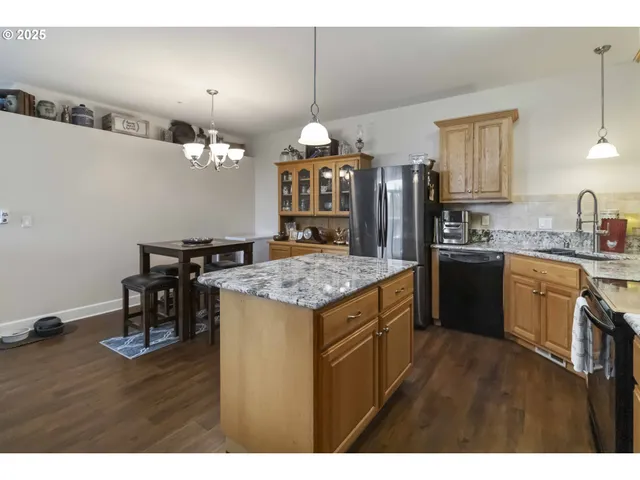 a kitchen with kitchen island granite countertop a sink cabinets and wooden floor