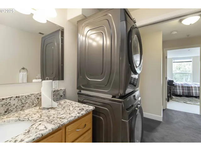a en suite bathroom with a granite countertop sink a mirror and shower