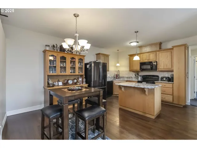 a kitchen with kitchen island granite countertop a sink cabinets and stainless steel appliances