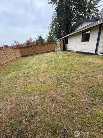 a view of a yard with wooden fence