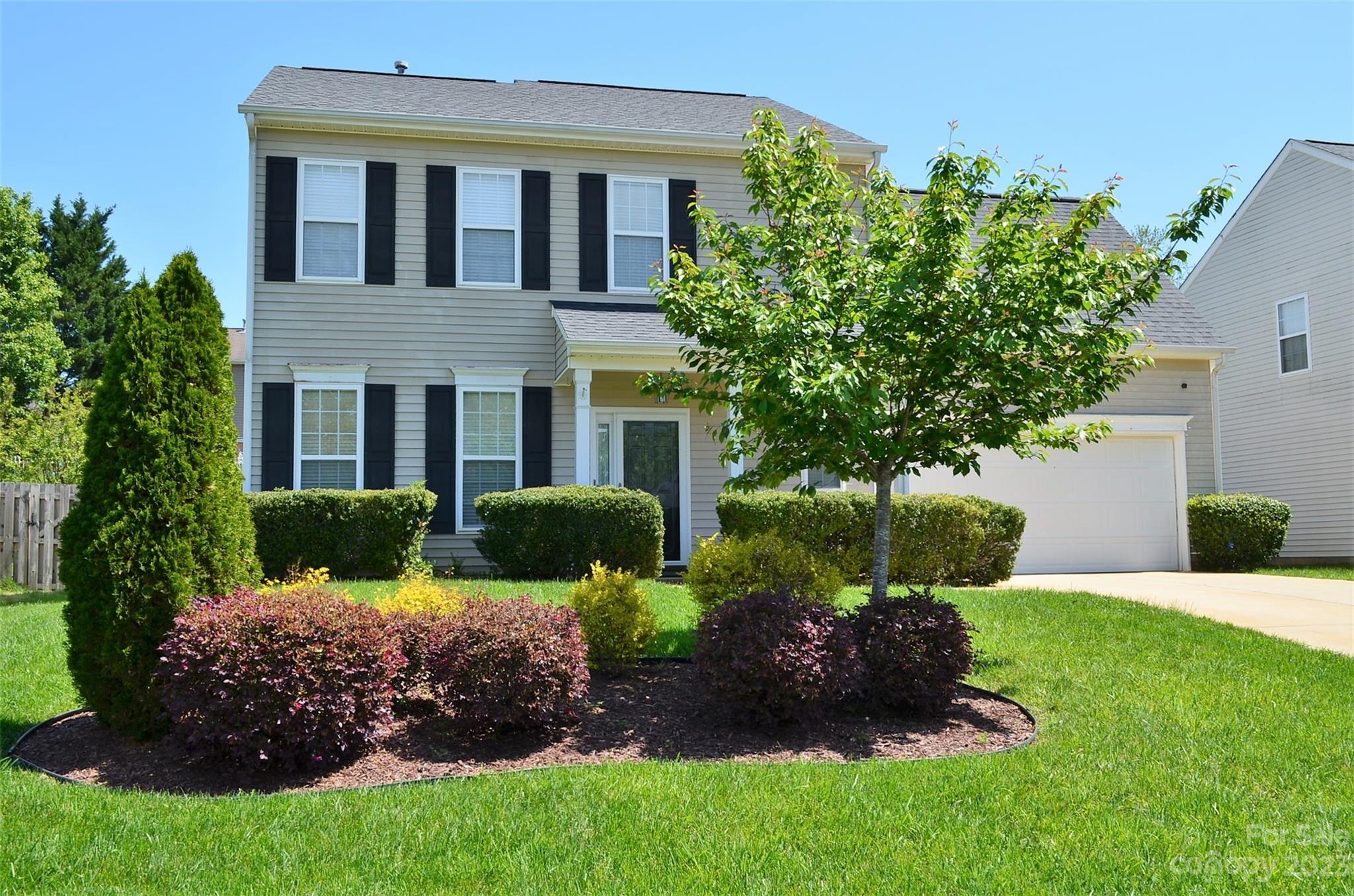 a front view of house with a garden
