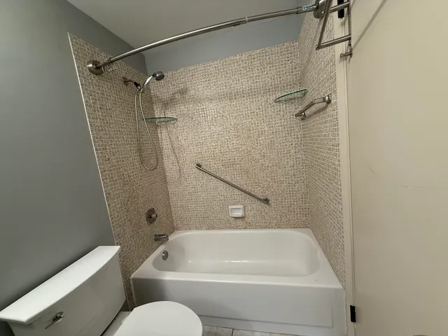 a bathroom with a granite countertop toilet sink and mirror