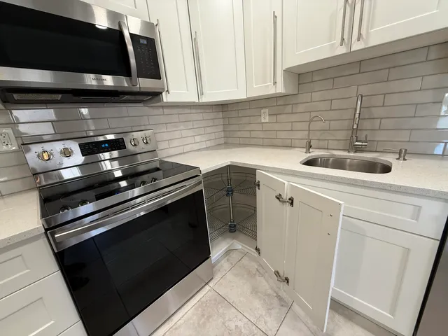 a kitchen with granite countertop a refrigerator sink and microwave