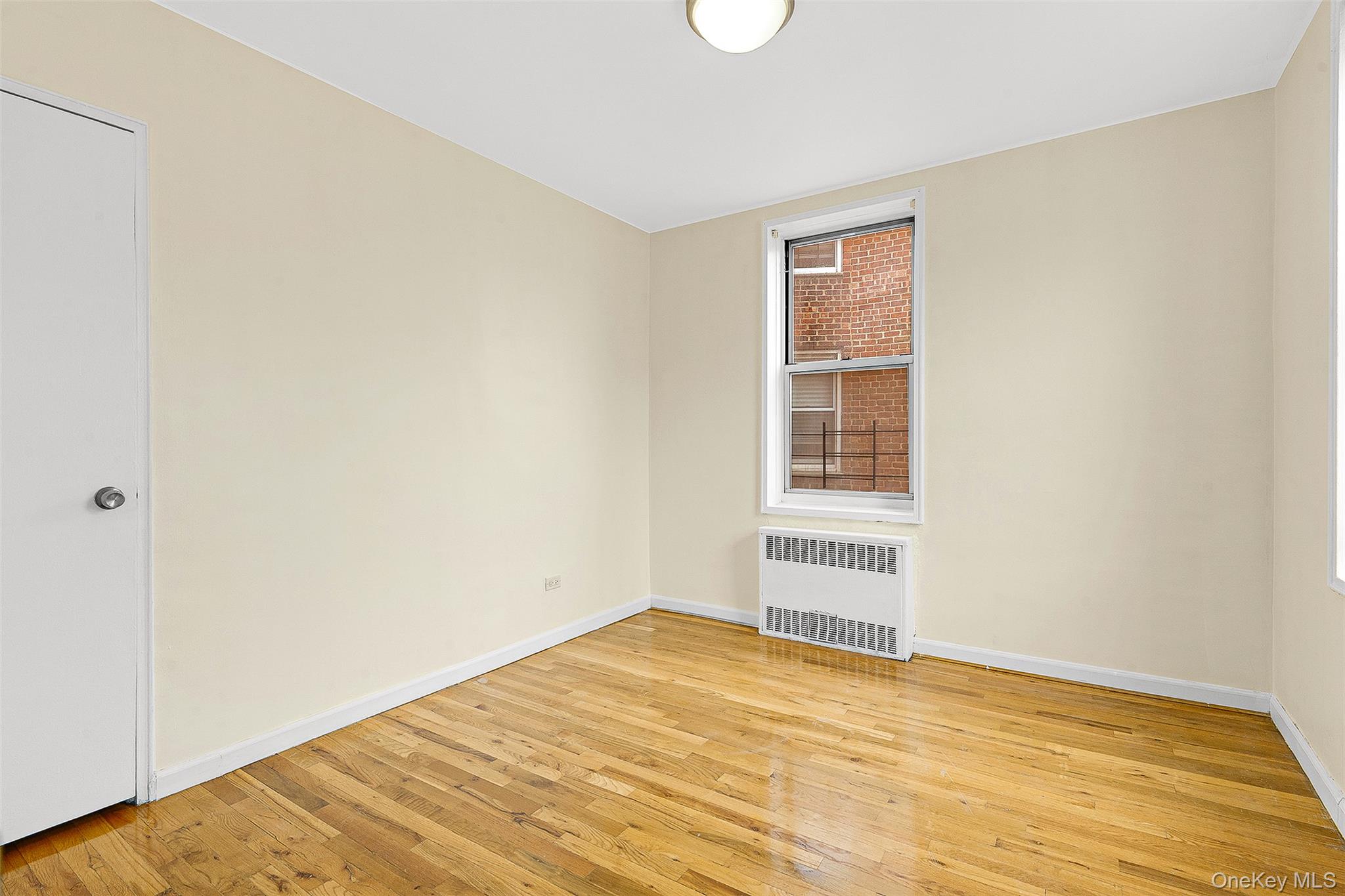 67-30 Clyde Street, Unit 6W Queens, NY 11375 - Photo 15 of 32 a view of empty room with wooden floor and fan