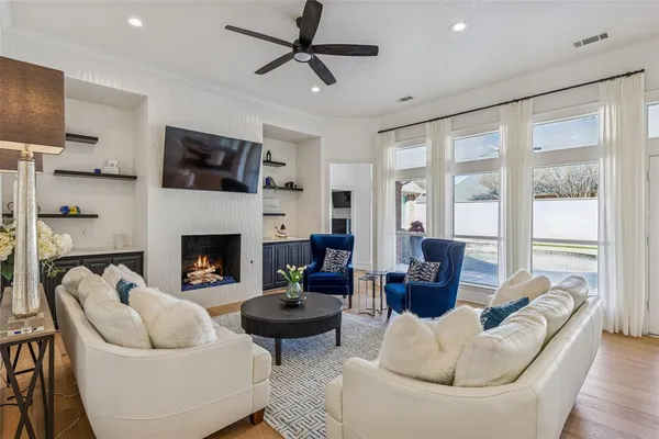 a living room with furniture a flat screen tv and a fireplace