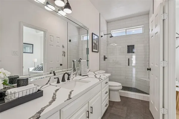 a bathroom with a double vanity sink mirror and toilet