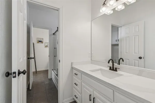 a bathroom with a sink vanity granite and a mirror