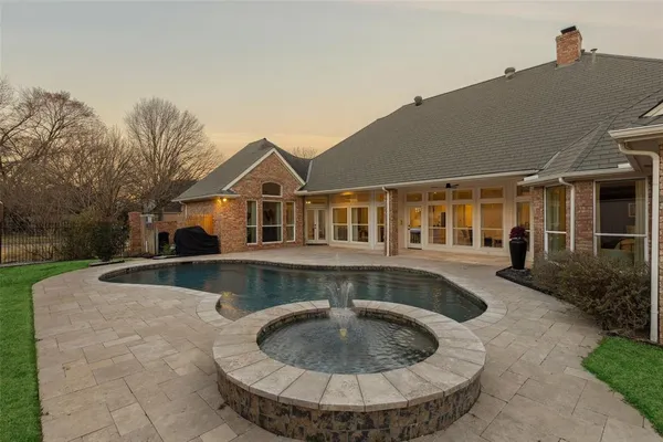 a view of a house with pool fire pit and chairs in the patio